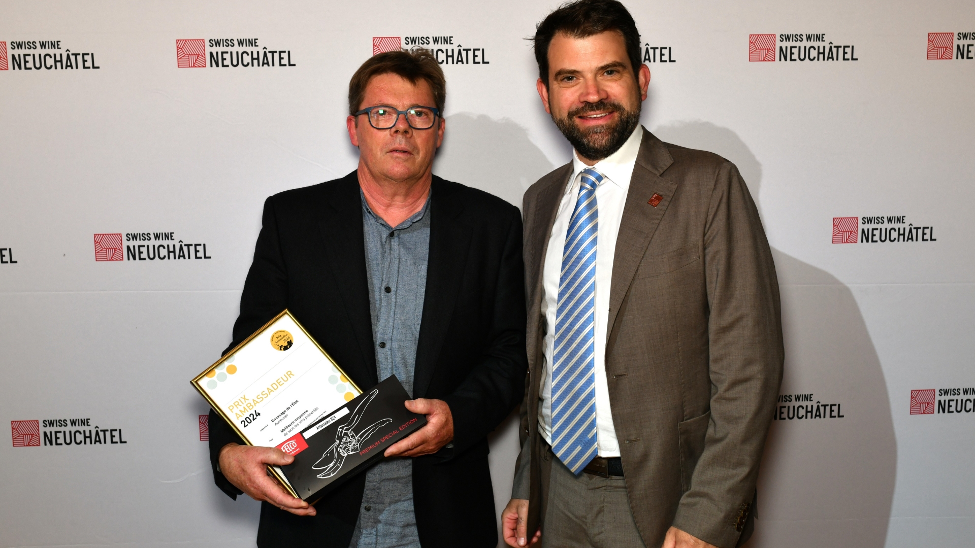 Damien Cottier (à droite), député neuchâtelois au  Conseil National et nouveau Président de la Fédération Suisse des Vignerons félicite l'Encavage de l'État, nommé Ambassadeur (photo m.à.d.)